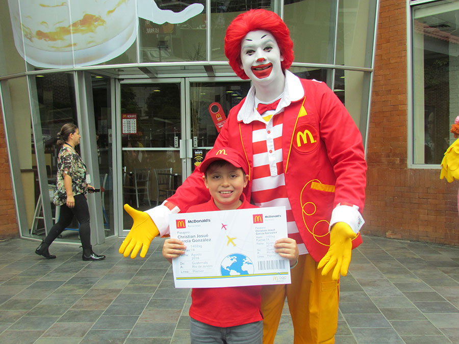 El niño que irá a los Juegos Olímpicos, Christian García, junto a Ronald McDonald, en las afueras del restaurante. Foto: El País de los Jóvenes